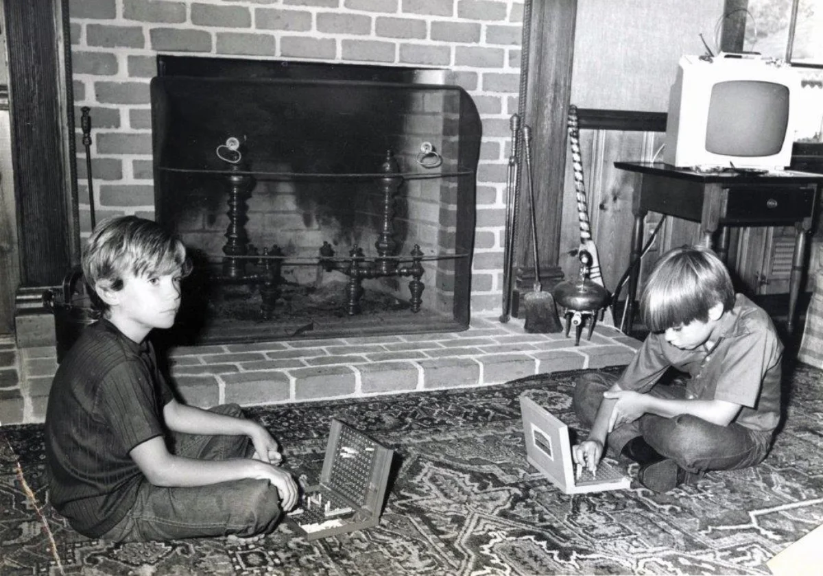 two boys playing batteship in front of a fireplace