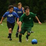 Boys playing soccer with Physical Education and Health program